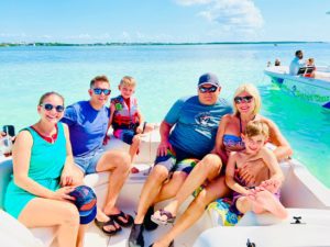 A group of excited tourists on a boat, ready for snorkeling, with the beautiful Islamorada coastline in the background