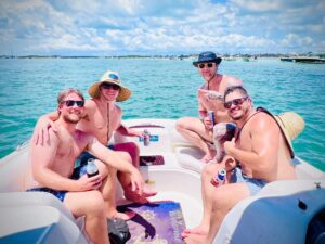 A group of happy adventurers on a boat, geared up for snorkeling with crystal-clear waters in the background and a clear blue sky overhead